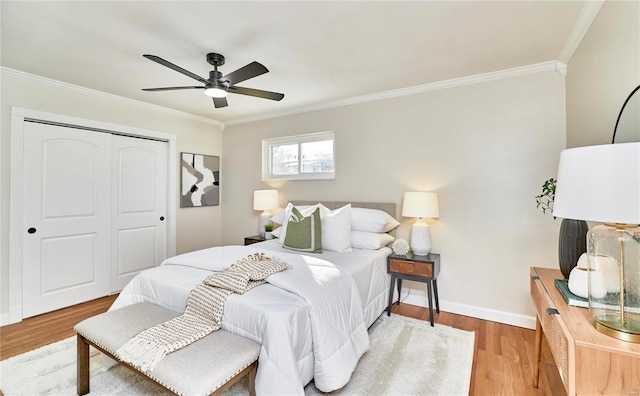 bedroom featuring wood-type flooring, ornamental molding, ceiling fan, and a closet