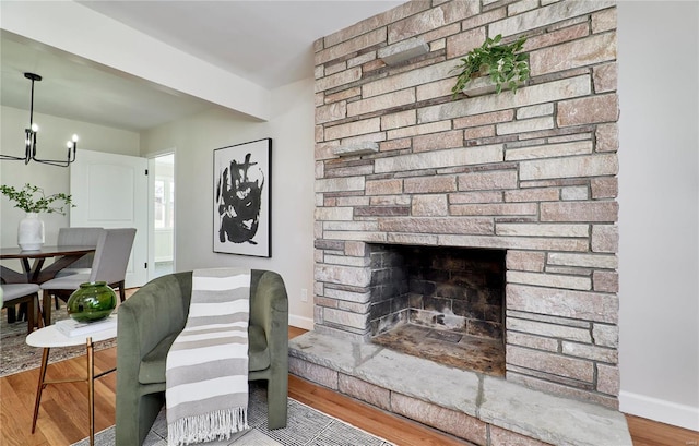 living room with a fireplace, wood-type flooring, and a chandelier