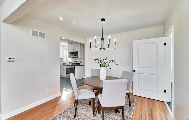 dining room with an inviting chandelier and light wood-type flooring