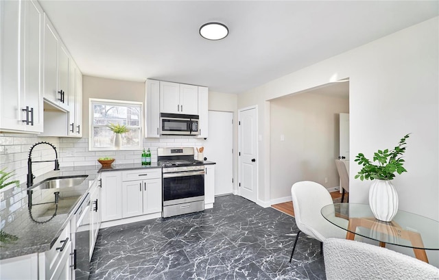 kitchen featuring sink, decorative backsplash, white cabinets, and appliances with stainless steel finishes