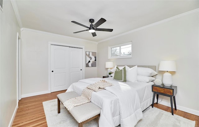 bedroom with hardwood / wood-style flooring, ornamental molding, a closet, and ceiling fan