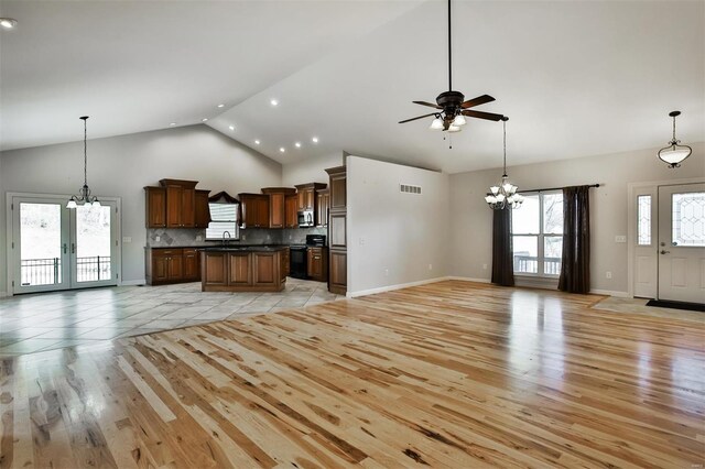 kitchen featuring sink, a center island, high vaulted ceiling, black electric range, and light hardwood / wood-style floors