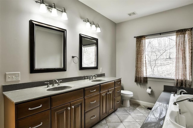 bathroom with vanity, a bathtub, plenty of natural light, and toilet