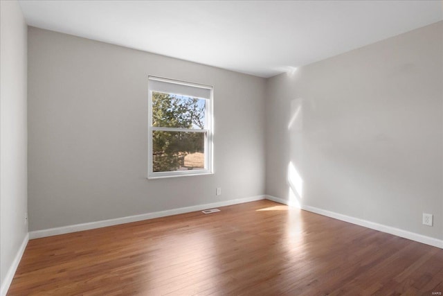 unfurnished room with hardwood / wood-style floors