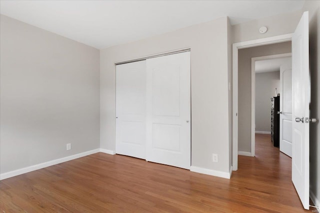 unfurnished bedroom featuring hardwood / wood-style floors and a closet