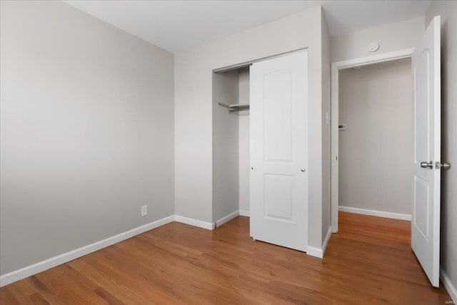 unfurnished bedroom with hardwood / wood-style flooring and a closet