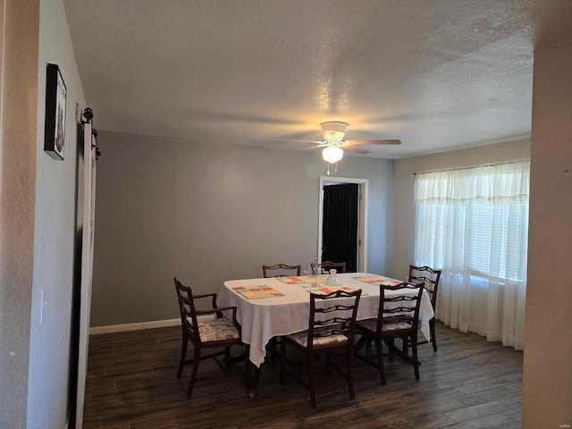 dining area with dark wood-type flooring, ceiling fan, and a textured ceiling