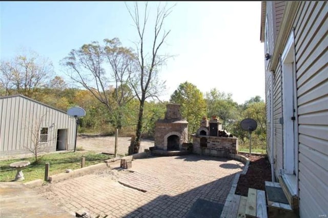 view of patio with an outdoor stone fireplace