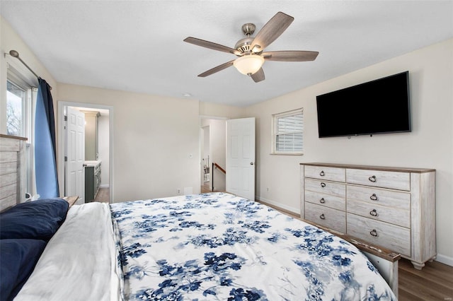 bedroom with ceiling fan, wood-type flooring, connected bathroom, and multiple windows