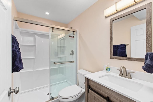 bathroom featuring an enclosed shower, vanity, and toilet