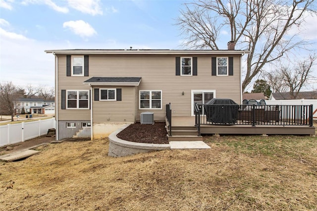 back of property with a wooden deck, a yard, and central AC