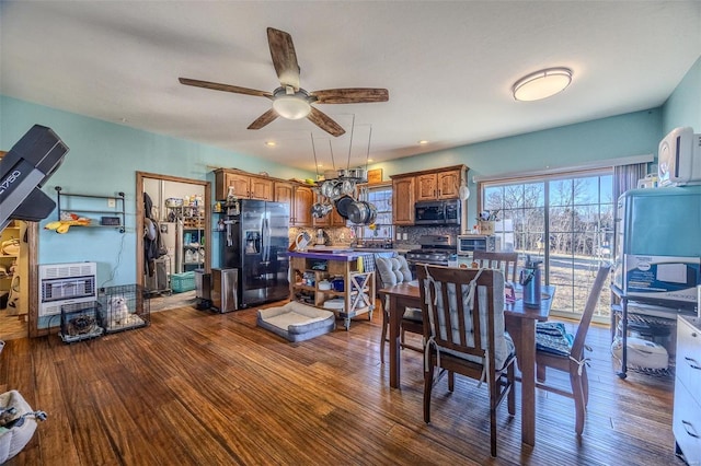 dining room with hardwood / wood-style flooring, heating unit, and ceiling fan