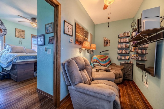 living area featuring ceiling fan and dark hardwood / wood-style flooring