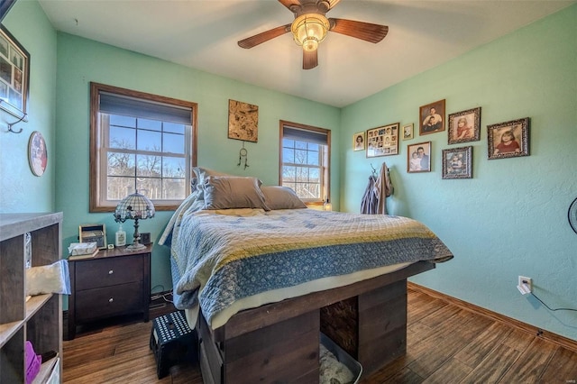 bedroom with dark hardwood / wood-style flooring and ceiling fan