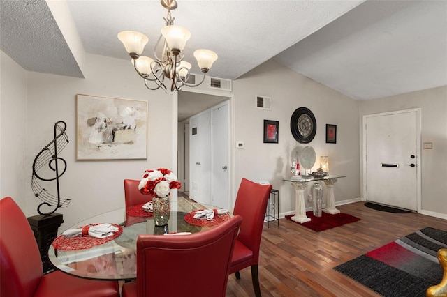 dining area with an inviting chandelier, lofted ceiling, and dark hardwood / wood-style floors