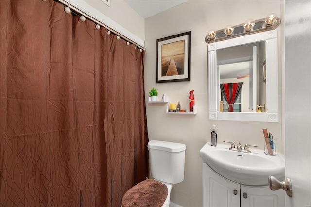 bathroom featuring vanity, walk in shower, and toilet