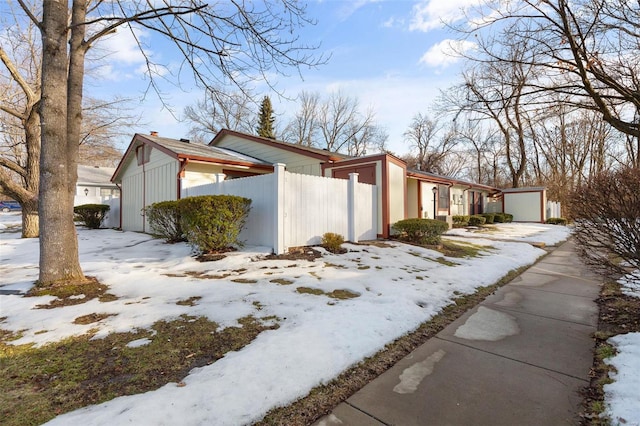 view of snow covered exterior featuring a shed