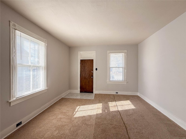 carpeted empty room featuring a textured ceiling