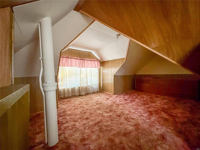 bonus room with wooden walls, vaulted ceiling, and carpet