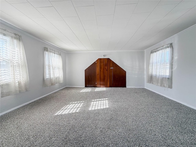 carpeted empty room featuring crown molding and plenty of natural light