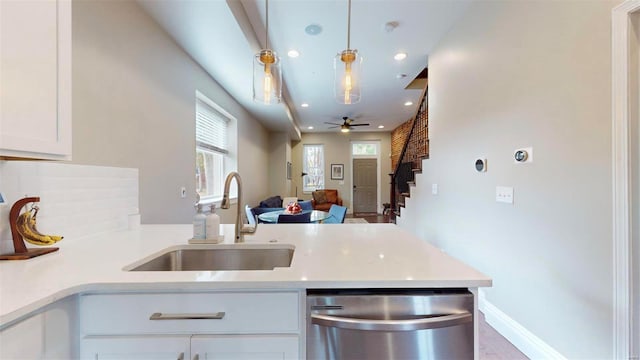 kitchen with dishwasher, sink, white cabinets, hanging light fixtures, and kitchen peninsula