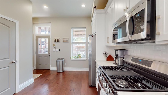 kitchen with tasteful backsplash, stainless steel appliances, dark hardwood / wood-style floors, and white cabinets