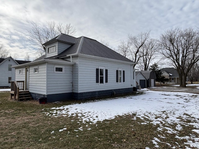 view of snowy exterior with a garage and a lawn