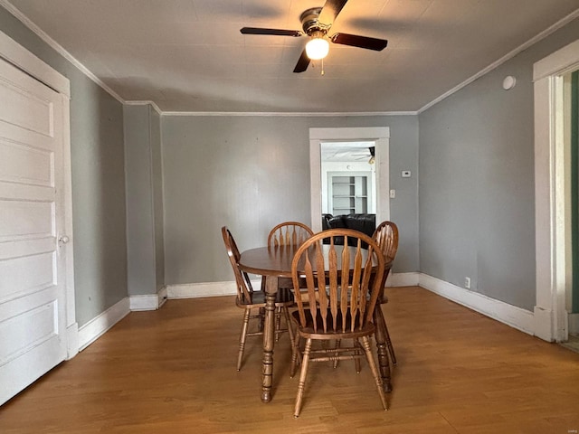 dining space featuring hardwood / wood-style flooring, crown molding, and ceiling fan