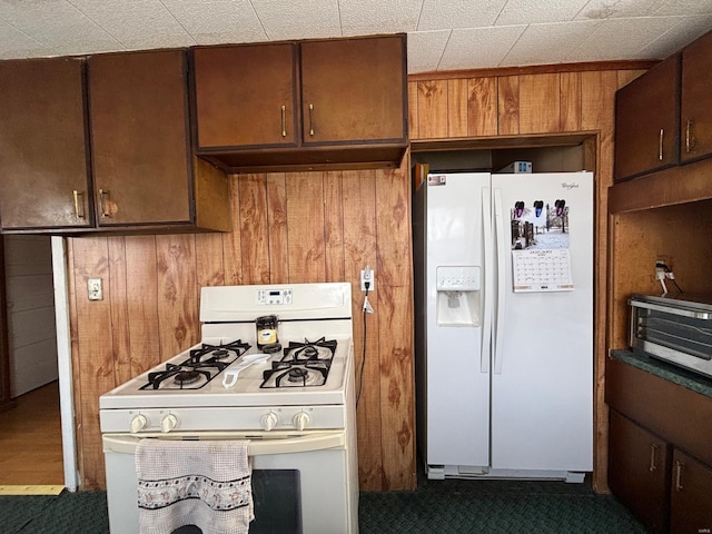 kitchen featuring white appliances and wooden walls