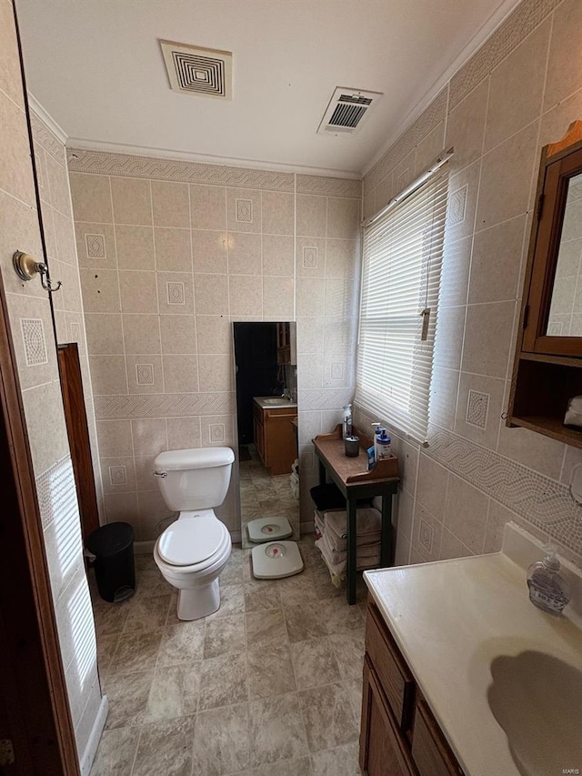 bathroom featuring ornamental molding, tile walls, vanity, and toilet