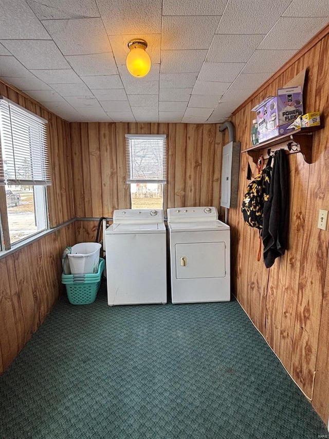 clothes washing area featuring carpet floors, independent washer and dryer, and wooden walls