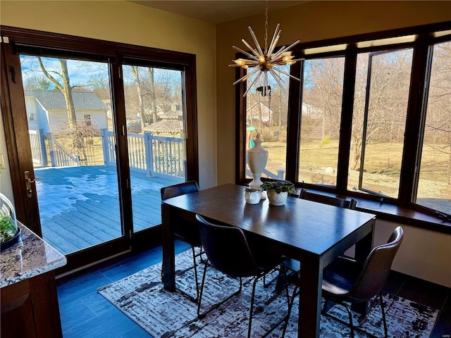 dining area featuring dark tile patterned flooring and a notable chandelier