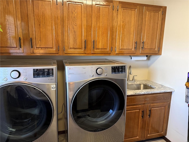 laundry area featuring separate washer and dryer, sink, and cabinets