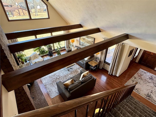 staircase with hardwood / wood-style flooring, lofted ceiling, and plenty of natural light