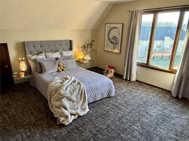 bedroom featuring dark colored carpet and lofted ceiling