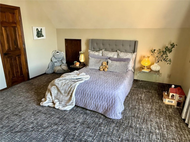 bedroom featuring dark colored carpet and lofted ceiling