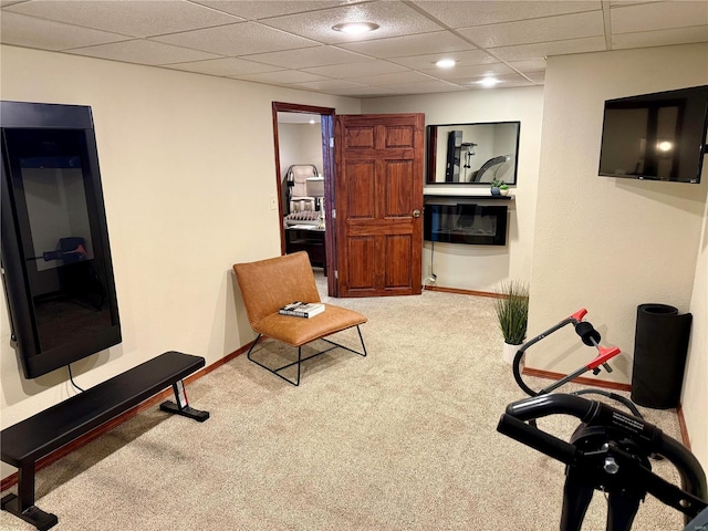 living area with carpet floors and a drop ceiling