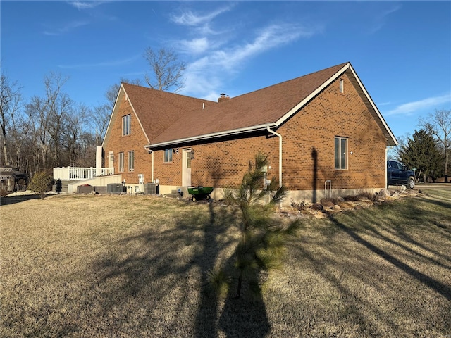 view of home's exterior with central AC and a lawn