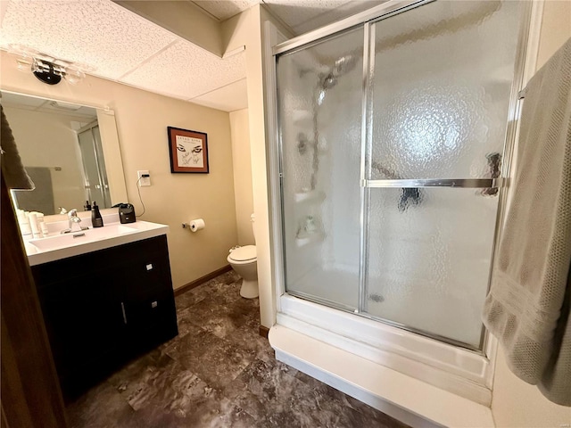 full bathroom with vanity, combined bath / shower with glass door, a drop ceiling, and toilet