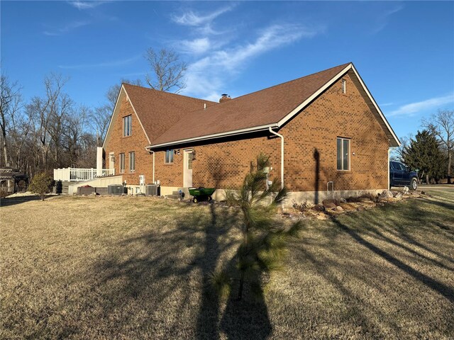 view of side of home with a yard and central air condition unit