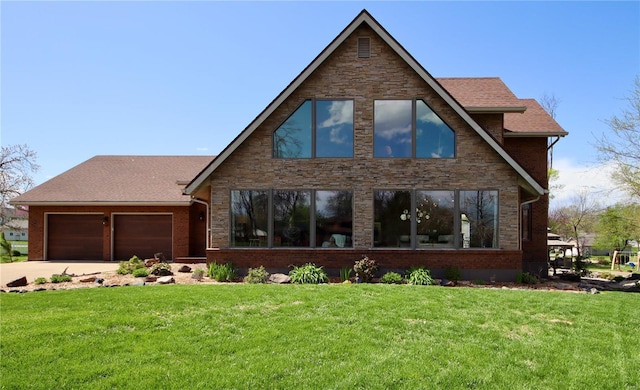 view of front of house featuring stone siding, a garage, a front yard, and driveway