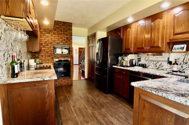 kitchen with light stone countertops, tasteful backsplash, dark wood-style flooring, and black appliances