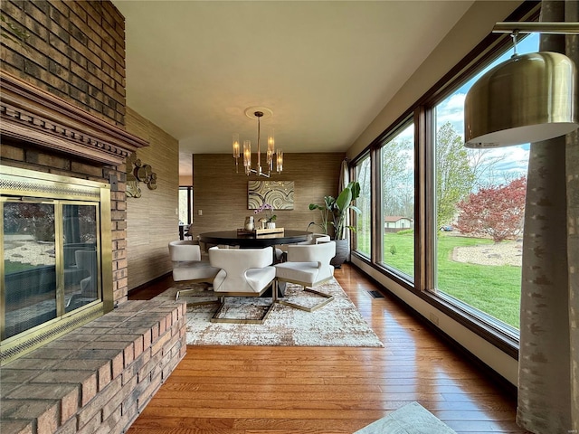 dining space with visible vents, a chandelier, and hardwood / wood-style flooring