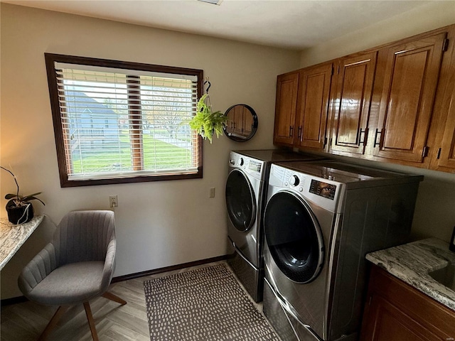 laundry area with independent washer and dryer, baseboards, and cabinet space
