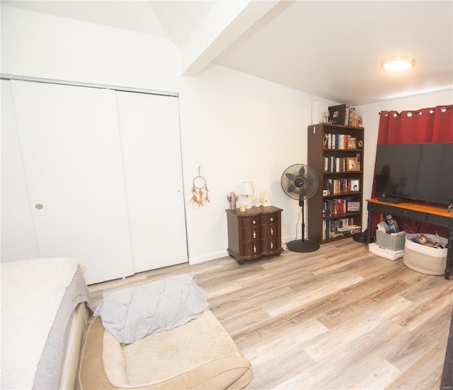 interior space with lofted ceiling with beams and light hardwood / wood-style floors