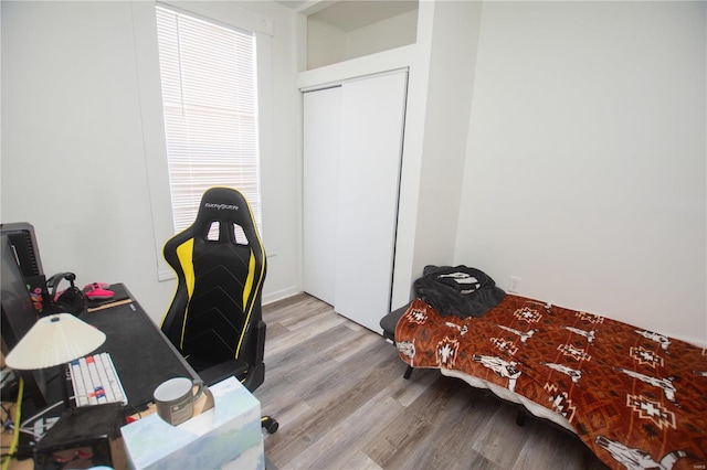 bedroom with light hardwood / wood-style floors and a closet