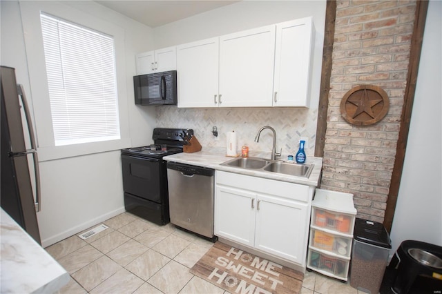 kitchen featuring sink, light tile patterned floors, black appliances, white cabinets, and decorative backsplash