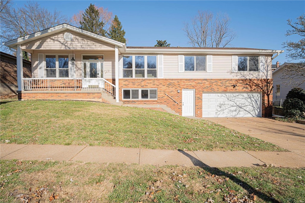 view of front of house featuring a garage, a porch, and a front yard