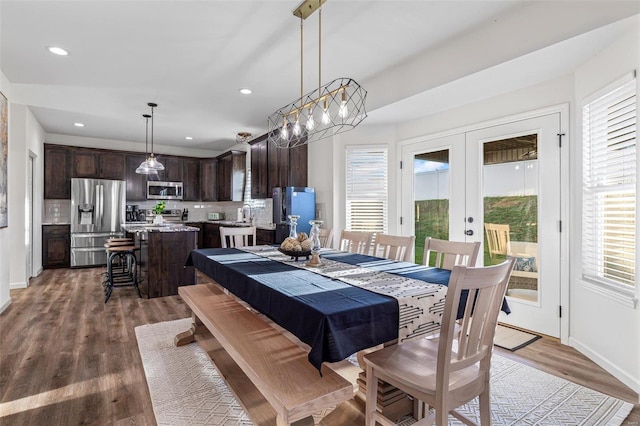 dining space with hardwood / wood-style flooring, sink, and french doors