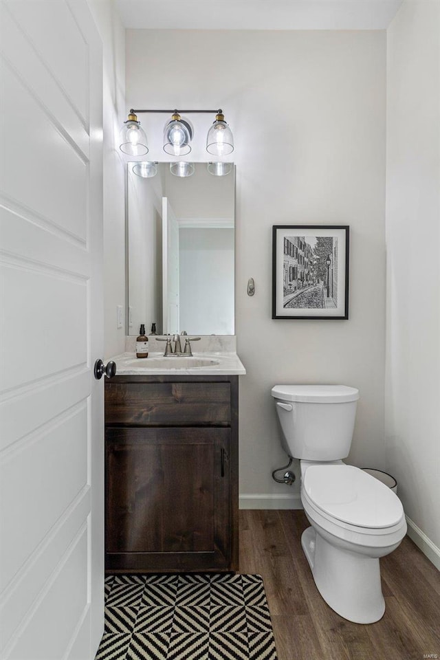 bathroom featuring hardwood / wood-style flooring, vanity, and toilet